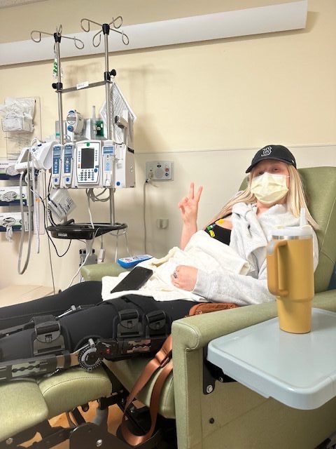 Abbi giving a peace sign during chemotherapy