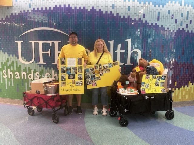 Volunteers delivering wagons of donations at UF Health Shands sign