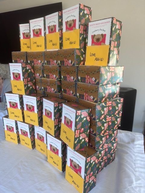 Stacks of Scentsy bedtime bear boxes labeled Love, Abbi