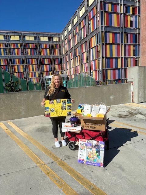 Volunteer outside hospital with wagon of donations